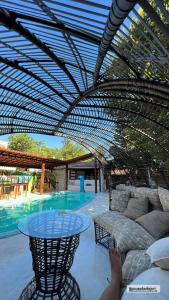 un patio cubierto con mesa y piscina en Pousada Vila Jeri, en Jericoacoara