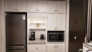 a kitchen with white cabinets and a black refrigerator at La Finca in Monterrey