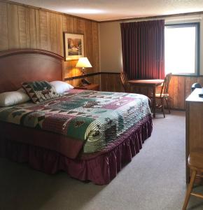 a bedroom with a bed and a table and chairs at Denali Park Hotel in Healy