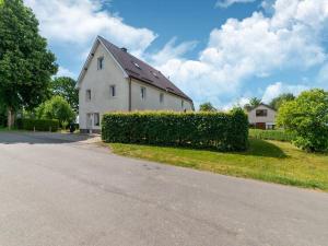 ein weißes Haus mit Hecke neben einer Straße in der Unterkunft Wonderful holiday home in Elsenborn with garden in Elsenborn