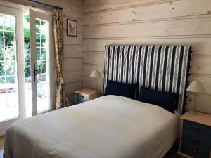 a bedroom with a white bed with a striped headboard at chalet in Provence near the beaches of Pampelonne in Grimaud
