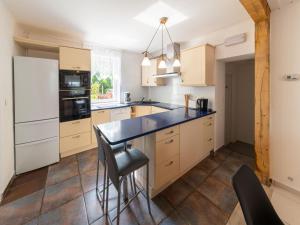 eine Küche mit einer schwarzen Theke und einem weißen Kühlschrank in der Unterkunft Wonderful holiday home in Elsenborn with garden in Elsenborn