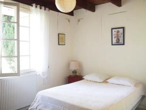 een witte slaapkamer met een bed en een raam bij holiday home, Pont-Saint-Esprit in Pont-Saint-Esprit