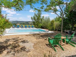 a pool with two green lawn chairs and a table at Lovely villa in Limoux with private pool in Limoux