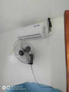 a white fan attached to a white wall at Jeno Tourist Inn in San Vicente