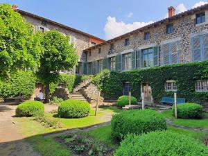 a large stone building with bushes in front of it at Maison pittoresque avec terrasse et BBQ, calme près de Langeac - FR-1-582-124 in Langeac