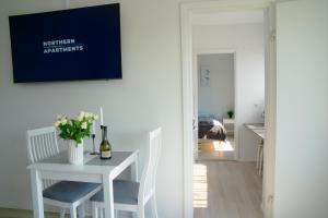 a white dining room with a table and a bottle of wine at Central 2-Room apartment in Oulu, parking in Oulu