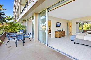 Maui Kaanapali Villas A209 في كانابالي: فناء فيه سرير وطاولة وكراسي