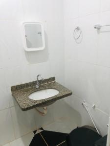 uma casa de banho com um lavatório numa parede branca em Pousada Voadores Jalapão em Mateiros mais 13 fotografias