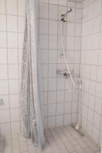 a shower curtain in a white tiled bathroom at 2-Room City center, parking in Oulu