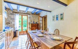 Il comprend une cuisine et une salle à manger avec une table et des chaises en bois. dans l'établissement Amazing Home In Creysse With Wifi, à Creysse