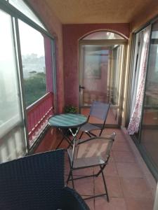 d'un balcon avec deux chaises, une table et quelques fenêtres. dans l'établissement Condominio Ilimay Las Cruces, à Las Cruces