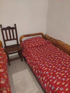 1 dormitorio con cama, silla de madera y silla en Pilpilcura en Dina Huapi