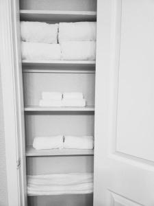 a closet with white towels on a shelf at LUX COMFORT in Arlington