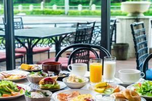 a table with plates of food and glasses of orange juice at HOTEL MYSTAYS Matsuyama in Matsuyama