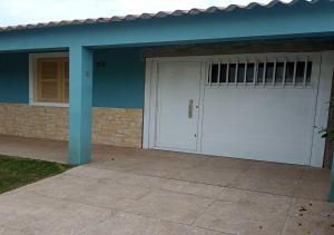 a garage with a white door and a house at Lugar perfeito para você e sua família in Rio Grande