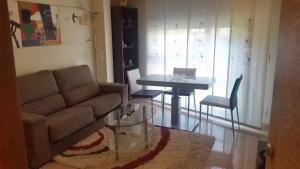 ein Wohnzimmer mit einem Sofa und einem Tisch in der Unterkunft Apartamento Carabuxeira 1 in Sanxenxo
