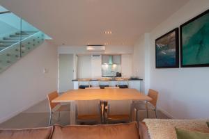 comedor con mesa de madera y sillas en Cable Bay Luxury 1 Bedroom Surf Villa, en Cable Bay