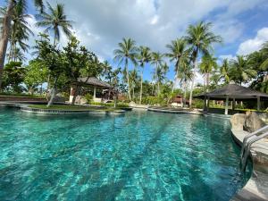 a pool at a resort with palm trees at Nongsa Village Peaceful Villa in private beach Resort in Nongsa