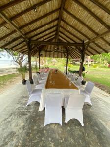 długi stół i krzesła pod pawilonem w obiekcie Nongsa Village Peaceful Villa in private beach Resort w mieście Nongsa