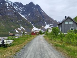 un camino de tierra con una casa y una montaña en Holiday home Reinfjord, en Spildra