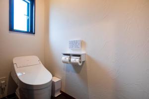 a small bathroom with a toilet and a window at The Villa Miyako in Hirara