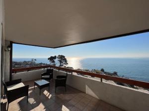 Un balcón con sillas y vistas al océano. en Departamento con insuperable vista Playa Amarilla Playa La Boca, en Concón