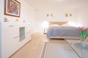 um quarto branco com uma cama e uma mesa de vidro em Haus Eva Mar am Meer Appartement 6 em Timmendorfer Strand