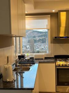 uma cozinha com um balcão com uma janela em Casa del Alto, a estrenar, 3 dormitorios, 2 baños em Esquel