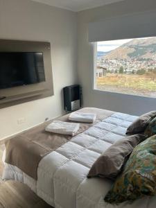 a bedroom with a large bed with a flat screen tv at Casa del Alto, a estrenar, 3 dormitorios, 2 baños in Esquel