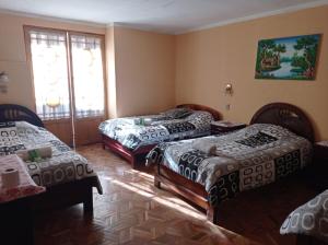 pokój z 3 łóżkami i oknem w obiekcie HOSTAL MAYA INN w mieście La Paz