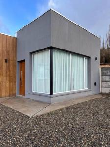 uma casa com uma grande janela do lado em Casa del Alto, a estrenar, 3 dormitorios, 2 baños em Esquel