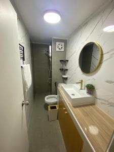 y baño con lavabo, aseo y espejo. en PTJ Style Condotel คอนโดเมืองทอง, en Ban Bang Phang