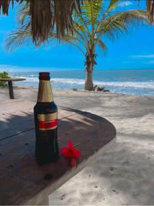 Una botella de cerveza sentada en una mesa en la playa en Cabanas Las Estrellas, en Palomino
