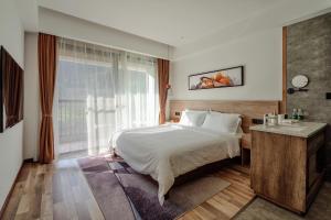 um quarto com uma cama e uma grande janela em National Forest Park(Yangjiajie ) MINI Inn em Zhangjiajie