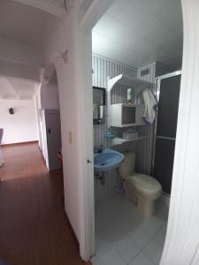 y baño con aseo y lavamanos. en Habitación con cama doble y baño privado, para descansar, en Bogotá