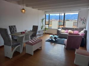 sala de estar con sofá, mesa y sillas en Habitación con cama doble y baño privado, para descansar, en Bogotá