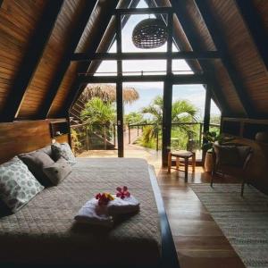 a bedroom with a bed and a large window at Bohemia Experience in Santa Teresa Beach