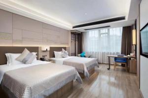 a hotel room with two beds and a desk at Morning Hotel, Wuhan Jinyin Lake Garden Expo Garden Yuya Yinhu City in Dongxihu