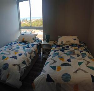 two beds in a room with a window at Dolphin Coast Getaway in Ballito +9 photos
