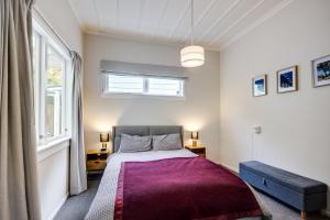 - une chambre avec un grand lit et une fenêtre dans l'établissement Central Cottage - Napier Holiday Home, à Napier