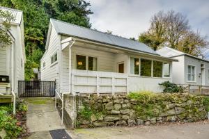 una casa bianca con un muro di pietra di Central Cottage - Napier Holiday Home a Napier