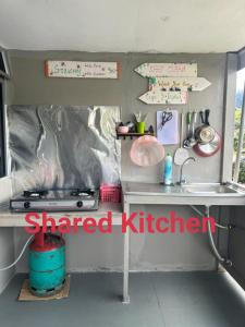 una pequeña cocina con fogones y fregadero en Dreamcatcher Homestay, Kundasang, en Ranau