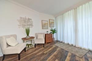 a living room with two chairs and a table at Hale Ono Loa 203 in Kahana