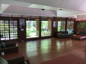 a large living room with wooden floors and windows at Baan Krating Phuket Resort -SHA Plus in Nai Harn Beach