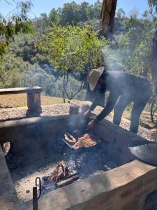 una persona está cocinando sobre un fuego en una parrilla en Cabaña La escondida - JuJuy- en San Salvador de Jujuy