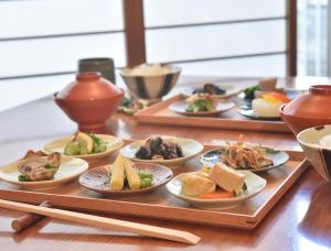 un tavolo con piatti di cibo su un tavolo con bacchette di Ryokan Sumiya Kihoan a Kameoka