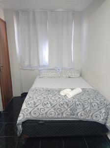 uma cama com duas toalhas brancas em cima em KITNET MOBILIADA - PENHA no Rio de Janeiro