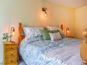 a bedroom with a bed with a blue comforter at Eton Cottage in Minehead