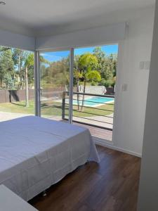 a bedroom with a bed and a large glass window at Casa para 4 personas en vista24uy, Bella Vista, Maldonado in Bella Vista